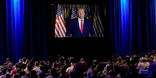 People listen as former President Donald Trump speaks remotely to an annual leadership meeting of the Republican Jewish Coalition Saturday, Nov. 19, 2022, in Las Vegas.