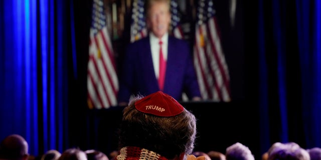 People listen as former President Donald Trump speaks remotely to an annual leadership meeting of the Republican Jewish Coalition Saturday, Nov. 19, 2022, in Las Vegas. 