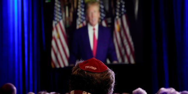 People listen as former President Donald Trump speaks remotely to an annual leadership meeting of the Republican Jewish Coalition Saturday, Nov. 19, 2022, in Las Vegas. (AP Photo/John Locher)