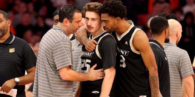Head coach Jared Grasso of the Bryant University Bulldogs speaks with Doug Edert and Sherif Gross-Bullock during the first half against the Syracuse Orange on Nov. 26, 2022.