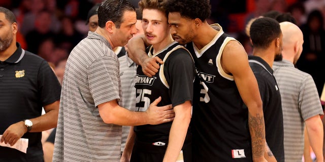 Head coach Jared Grasso of the Bryant University Bulldogs speaks with Doug Edert and Sherif Gross-Bullock during the first half against the Syracuse Orange on Nov. 26, 2022.