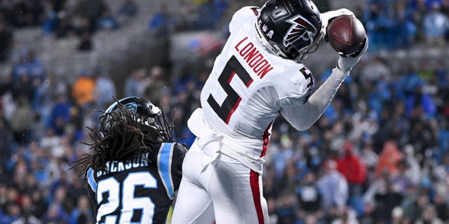 No. 5 Drake London of the Atlanta Falcons catches a touchdown over No. 26 Donte Jackson of the Carolina Panthers in the third quarter at Bank of America Stadium.