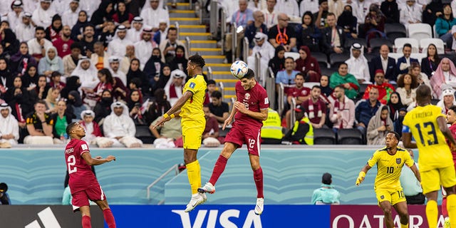 Karim Boudiaf of the Qatar national soccer team, center right, heads the ball during the opening match of the FIFA World Cup between hosts Qatar and Ecuador at the Al Bayt Stadium in Al Khor, Qatar, Sunday, November 20. of 2022.
