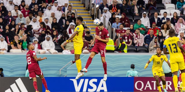 Qatar national football team Karim Boudiaf, centre-right, heads the ball during the opening match of the FIFA World Cup between hosts Qatar and Ecuador at Al Bayt Stadium in Al Khor, Qatar, Sunday, November 20, 2022.