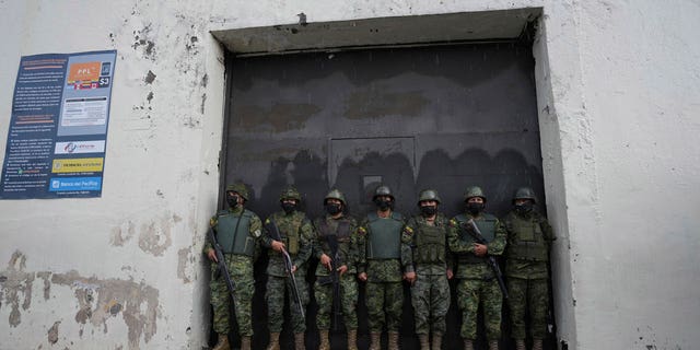 Soldiers guard an entrance to the Inca jail where eight inmates were killed during a prison riot, according to Police Commander Victor Herrera, in Quito, Ecuador, on Nov. 18, 2022. 