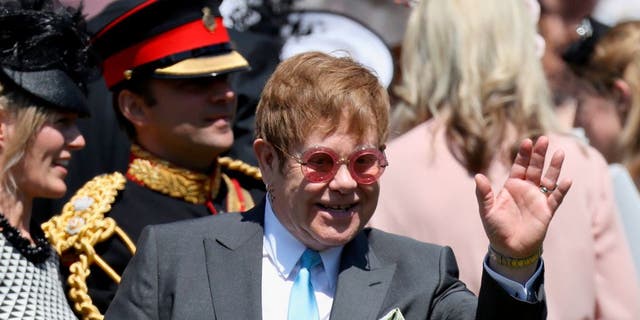 Elton John acena ao deixar a cerimônia de casamento do Príncipe Harry e Meghan Markle na Capela de São Jorge no Castelo de Windsor em 19 de maio de 2018.