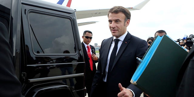 French President Emmanuel Macron gives a thumb up sign as he prepares to board his car upon arrival at Ngurah Rai International Airport ahead of the G20 Summit in Bali, Indonesia, Monday, Nov. 14, 2022. 