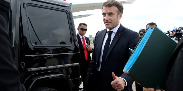 French President Emmanuel Macron gives a thumb up sign as he prepares to board his car upon arrival at Ngurah Rai International Airport ahead of the G20 Summit in Bali, Indonesia, Monday, Nov. 14, 2022.