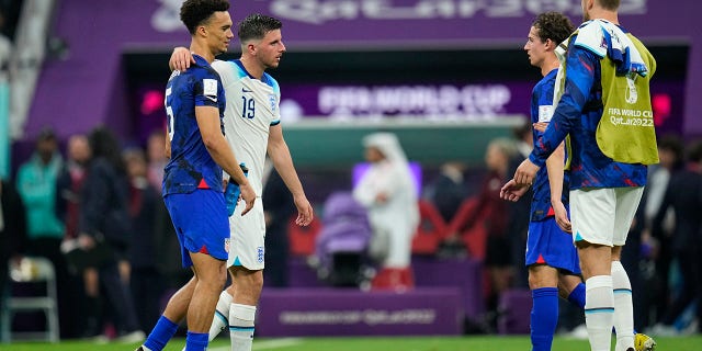 Antonee Robinson of the United States, left, and Mason Mount of England, second from left, walk on the pitch at the end of the World Cup Group B soccer match between England and the United States, at the Stadium Al Bayt in Al Khor, Qatar, Friday, November 25, 2022.