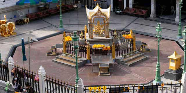 Flower sellers sit in front of the Erawan Shrine in Bangkok, Thailand, on August 3, 2021. The trial of the two suspects accused of bombing the Erawan Shrine in 2015 has resumed.
