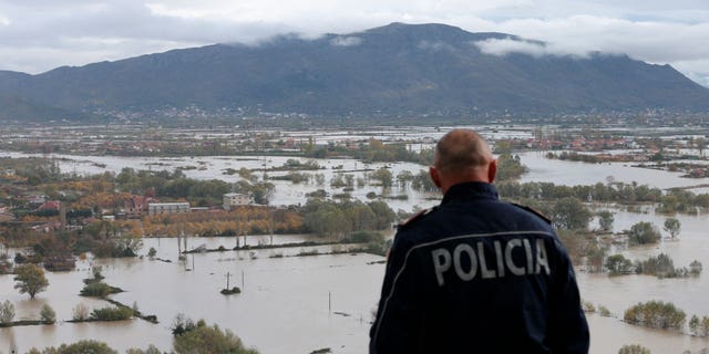 A policeman looks over a flooded area near Shkoder town, northwestern Albania, on Nov. 21, 2022.