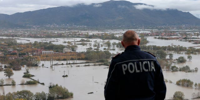 A policeman looks at a flooded area near the city of Shkoder in northwestern Albania on November 21, 2022.