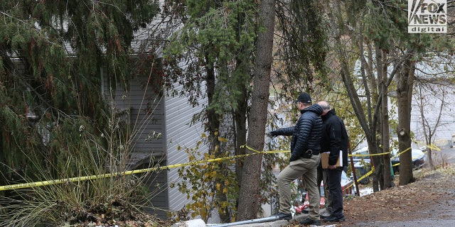 Investigators look at the rear of the house where four University of Idaho students were stabbed in their sleep 