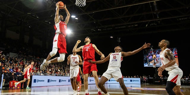 Canada's Jean-Victor Mukama dunks as teammate Owen Klassen and Panama's Eric Romero, center, look on during FIBA World Cup qualifiers action in Edmonton, Alberta, on Sunday.