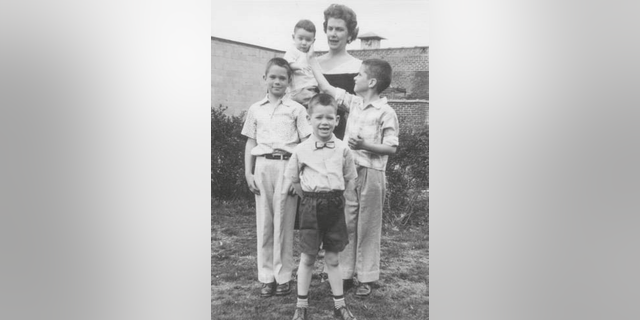 Mary Ann Crescenz holds her son Joe while her older boys, from left, Charlie, Pete and Michael, pose in the backyard of their Philadelphia home, 1957. (Family photo via Casemate)
