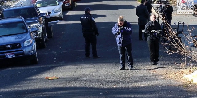 A forensics team returned to the street in front of the crime scene to measure tire marks.