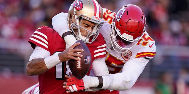 San Francisco 49ers quarterback Jimmy Garoppolo, left, is waved off by Kansas City Chiefs defensive end Frank Clark for safety during the second half of an NFL football game in Santa Clara, California on Sunday, October 23, 2022. 