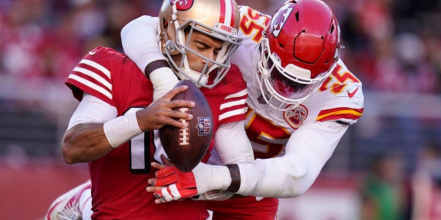 El mariscal de campo de los 49ers de San Francisco, Jimmy Garoppolo, a la izquierda, es despedido por el ala defensiva de los Kansas City Chiefs, Frank Clark, por seguridad durante la segunda mitad de un partido de fútbol americano de la NFL en Santa Clara, La California, el domingo 23 de octubre de 2022. 