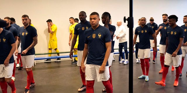 France's soccer team player Kylian Mbappe, center, leaves the photo group session, at Clairefontaine training center, south of Paris, Tuesday, Nov. 15, 2022. Defending champion France opens against Australia on Nov. 22, and the squad will fly to Qatar on Wednesday.