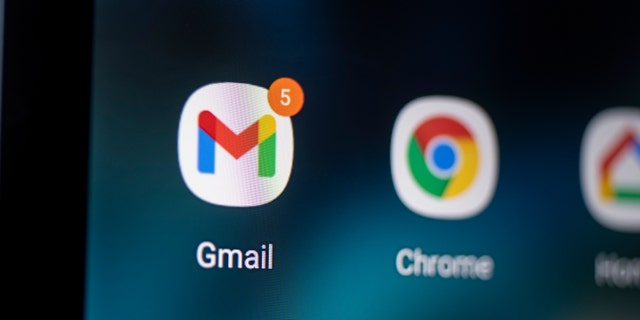 Smartphone surface  is seen with logo of Gmail app.