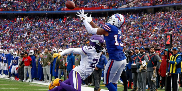 Buffalo Bills wide receiver Gabe Davis, #13, catches a touchdown pass as Minnesota Vikings cornerback Akayleb Evans, #21, tries to defend in the first half of an NFL football game, Sunday, Nov. 13, 2022, in Orchard Park, New York.