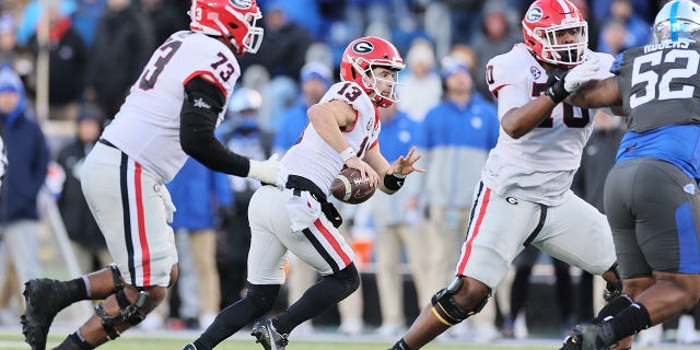 Stetson Bennett (13) of the Georgia Bulldogs runs with the ball against the Kentucky Wildcats at Kroger Field on November 19, 2022, in Lexington, Ky.