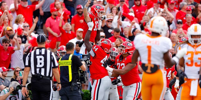 Stetson Bennett (13) of the Georgia Bulldogs celebrates with teammates after scoring a touchdown against the Tennessee Volunteers during the first quarter at Sanford Stadium Nov. 5, 2022, in Athens, Ga.