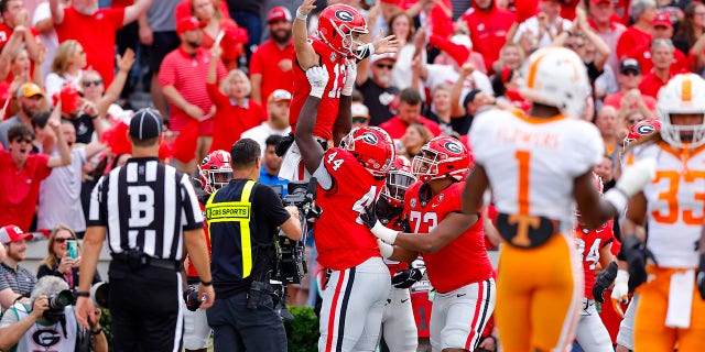 Stetson Bennett (13) of the Georgia Bulldogs celebrates with teammates after scoring a touchdown against the Tennessee Volunteers during the first quarter at Sanford Stadium November 5, 2022, in Athens, Georgia.