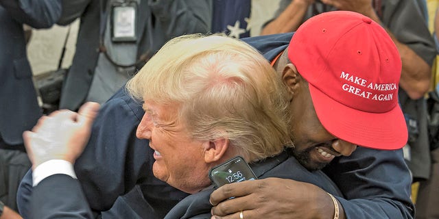 Rapper Kanye West embraces former President Donald Trump in the White House's Oval Office on October 11, 2018. 
