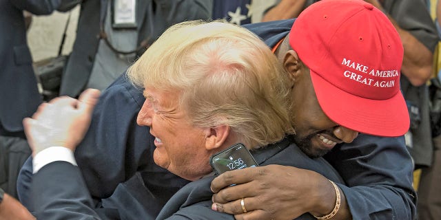 American rapper and producer Kanye West embraces President Donald Trump in the White House's Oval Office, Washington DC, on October 11, 2018.