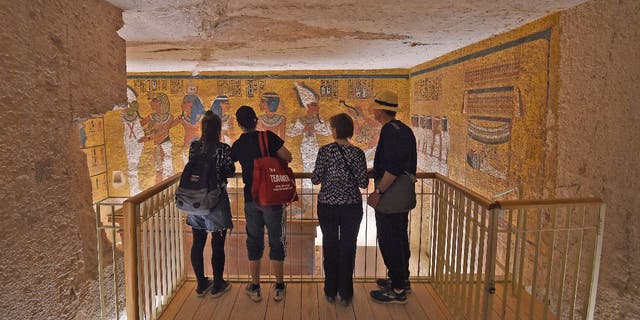 A group of tourists take a look at Pharaoh Tutankhamun's golden sarcophagus, which is on display in the burial chamber of his underground tomb (KV62) in the Valley of the Kings.