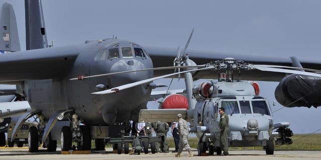 A U.S Air Force Seahawk Helicopter stands in front of a B-52 bomber on a runway on the opening day of the Australian International Airshow and Aerospace and Defence Expo in Melbourne March 1, 2011. 