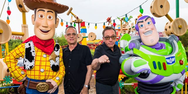 LAKE BUENA VISTA, FLORIDA - JUNE 08: In this Handout provided by Disney Resorts, Stars from DisneyPixars Toy Story 4 Woody (in costume), Tom Hanks (2nd-L), Tim Allen (2nd-R) and Buzz Lightyear (in costume) appear with characters from the film inside Toy Story Land at Disneys Hollywood Studios at Walt Disney World Resort on June 8, 2019 in Lake Buena Vista, Florida. (Photo by Matt Stroshane/Disney Resorts via Getty Images)