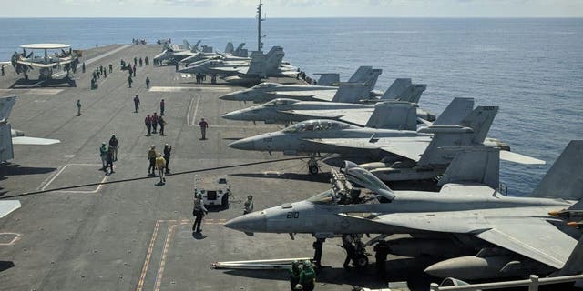 This photograph taken on Oct. 16, 2019 shows US Navy F/A-18 Super Hornet multi-role fighters and an EA-18G Growler electronic warfare aircraft, second right, aboard the aircraft carrier USS Ronald Reagan (CVN-76) while cruising in the South China Sea bound for Singapore. 
