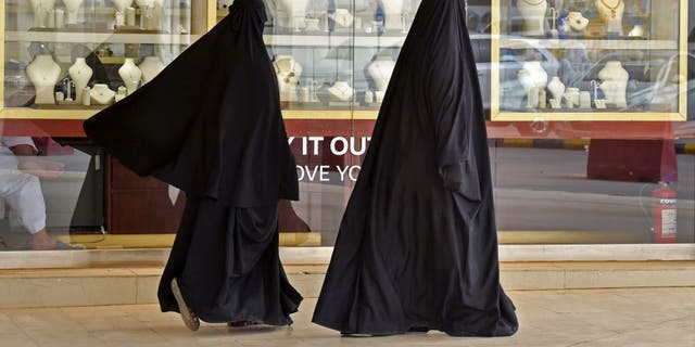 Saudi women walk past jewellers at the Taiba gold market in the capital Riyadh on April 30, 2020, after the partial lifting of the curfew.