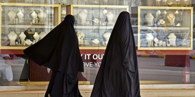 Saudi women walk past jewelers at the Taiba gold market in the capital Riyadh on April 30, 2020, after the partial lifting of the curfew.