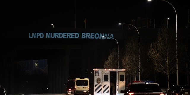 A projected phrase, LMPD MURDERED BREONNA, is seen on an overpass as Louisville Metro Police Department officers drive toward downtown on March 13, 2021, in Louisville, Kentucky.