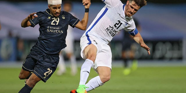 Esteghlal's defender Voria Ghafouri, right, is marked by Ahli's forward Abdulrahman Ghareeb, left, during the AFC Champions League Group C match between Saudi's Al-Ahli and Iran's Esteghlal on April 27, 2021, at the King Abdullah sport city stadium in the Saudi city of Jeddah. 