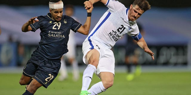 Esteghlal's defender Voria Ghafouri, right, is marked by Ahli's forward Abdulrahman Ghareeb, left, during the AFC Champions League Group C match between Saudi's Al-Ahli and Iran's Esteghlal on April 27, 2021, at the King Abdullah sport city stadium in the Saudi city of Jeddah.