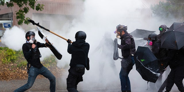 Members of the Proud Boys, left, clash with Antifa activists following a rally on August 22, 2021, in Portland, Oregon.