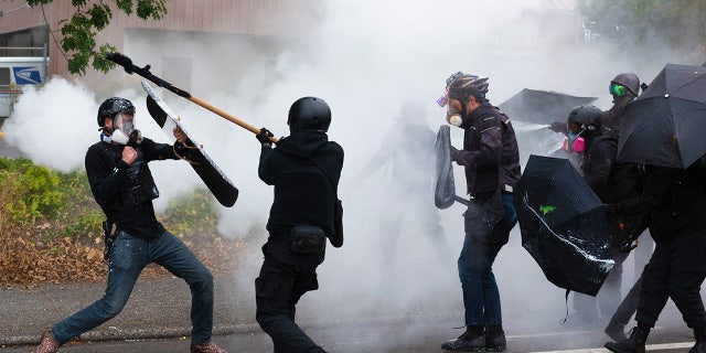 Members of the Proud Boys, left, clash with Antifa activists following a rally on August 22, 2021, in Portland, Oregon.