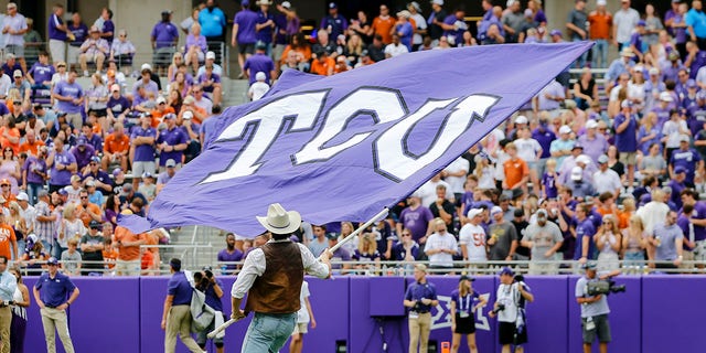 A TCU Horned Frogs flag runner flies the TCU flag after a touchdown during a game against the Texas Longhorns Oct. 2, 2021, at Amon G. Carter Stadium in Fort Worth, Texas. 