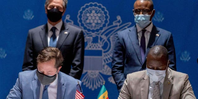 U.S. Secretary of State Antony Blinken (background L) and Senegal's Minister of Economy, Planning and International Cooperation Amadou Hott (background R) watch ABD Group CEO John Nevergole (L) and Ageroute Director General Ibrahima Ndiaye (R) sign an agreement during a commercial diplomatic event with U.S. companies and the government of Senegal at the Radisson Blu Hotel in Dakar, on November 20, 2021.