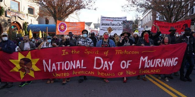 People march during the National Day of Mourning demonstration on Thanksgiving Day, Nov. 25, 2021, in Plymouth, Massachusetts.