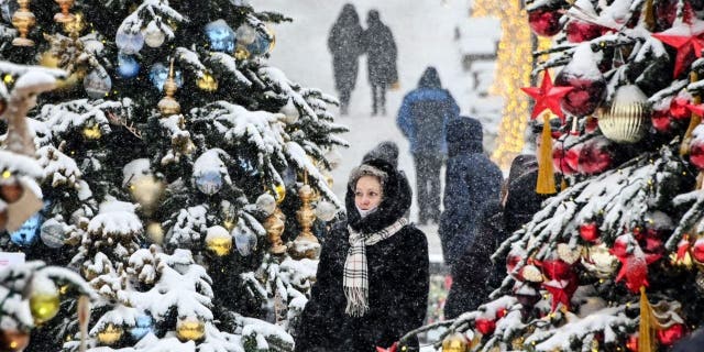 People walk past Christmas and New Year's decorations in downtown Moscow Dec. 25, 2021.