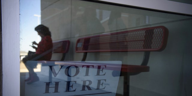 FILE PHOTO: A voter sits on a bench outside a polling location in Texas. 