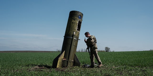 TOPSHOT - A Ukrainian serviceman looks at a Russian ballistic missile's booster stage that fell in a field in Bohodarove, eastern Ukraine, on April 25, 2022, amid the Russian invasion of Ukraine.