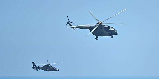 Chinese military helicopters fly past Pingtan island, one of mainland China's closest point from Taiwan, in Fujian province on August 4, 2022, ahead of massive military drills off Taiwan following US House Speaker Nancy Pelosi's visit to the self-ruled island.