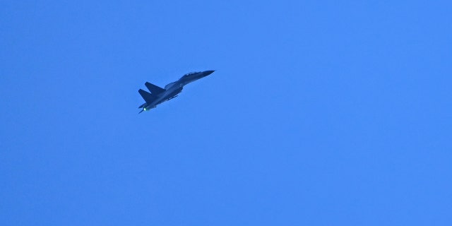 A Chinese military jet flies over Pingtan island, one of mainland China's closest points to Taiwan, in Fujian province on August 6, 2022. 