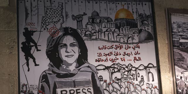 A mural depicting slain Palestinian-American journalist Shireen Abu Akleh is illuminated with headlights on a street in the Arab town of Umm Al-Fahm in northern Israel, on September 5, 2022. 